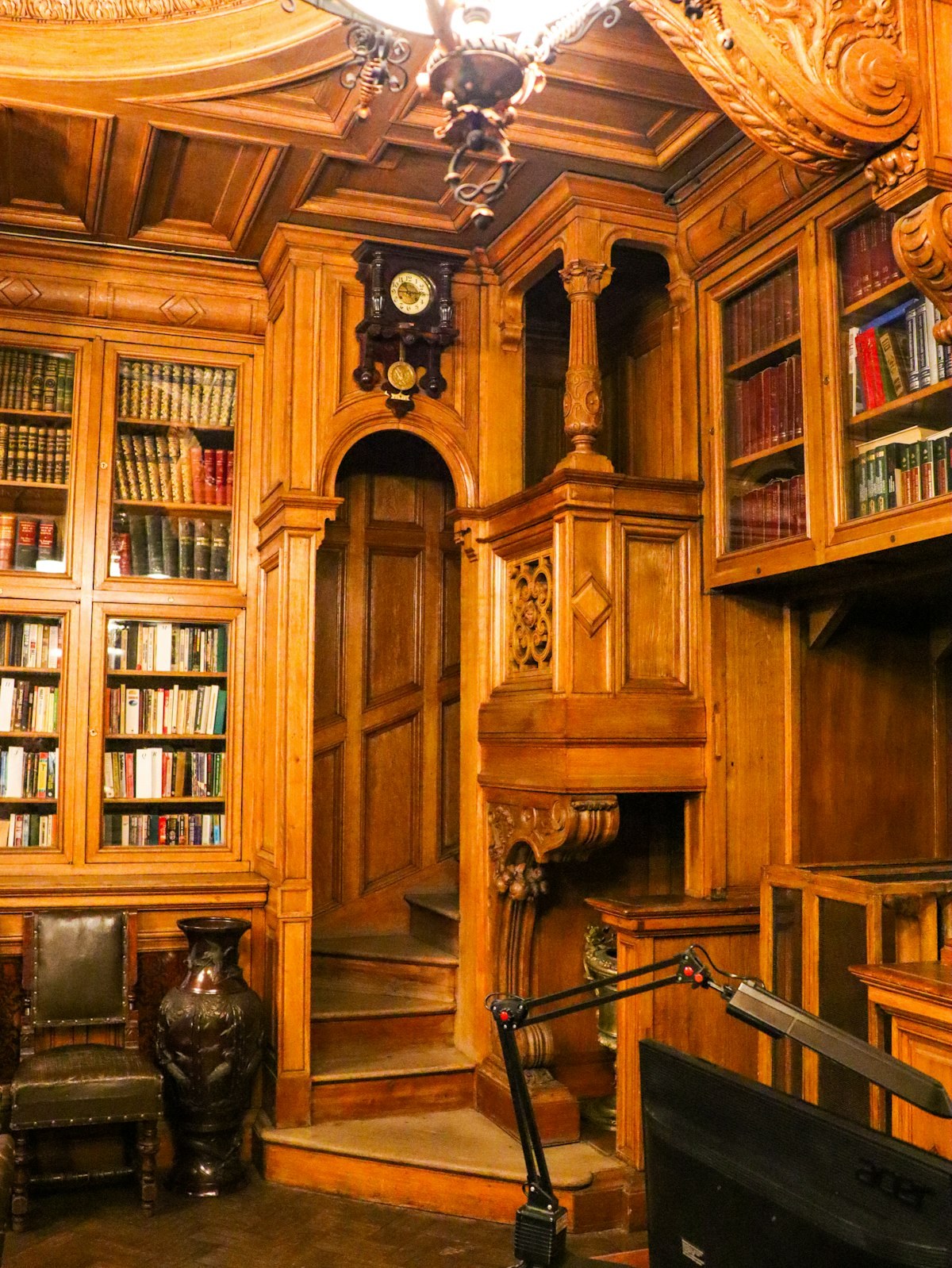 Klasyczna biblioteka z drewnianymi regałami i dekoracyjnym stropem